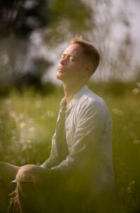 a man sitting in a field of tall grass